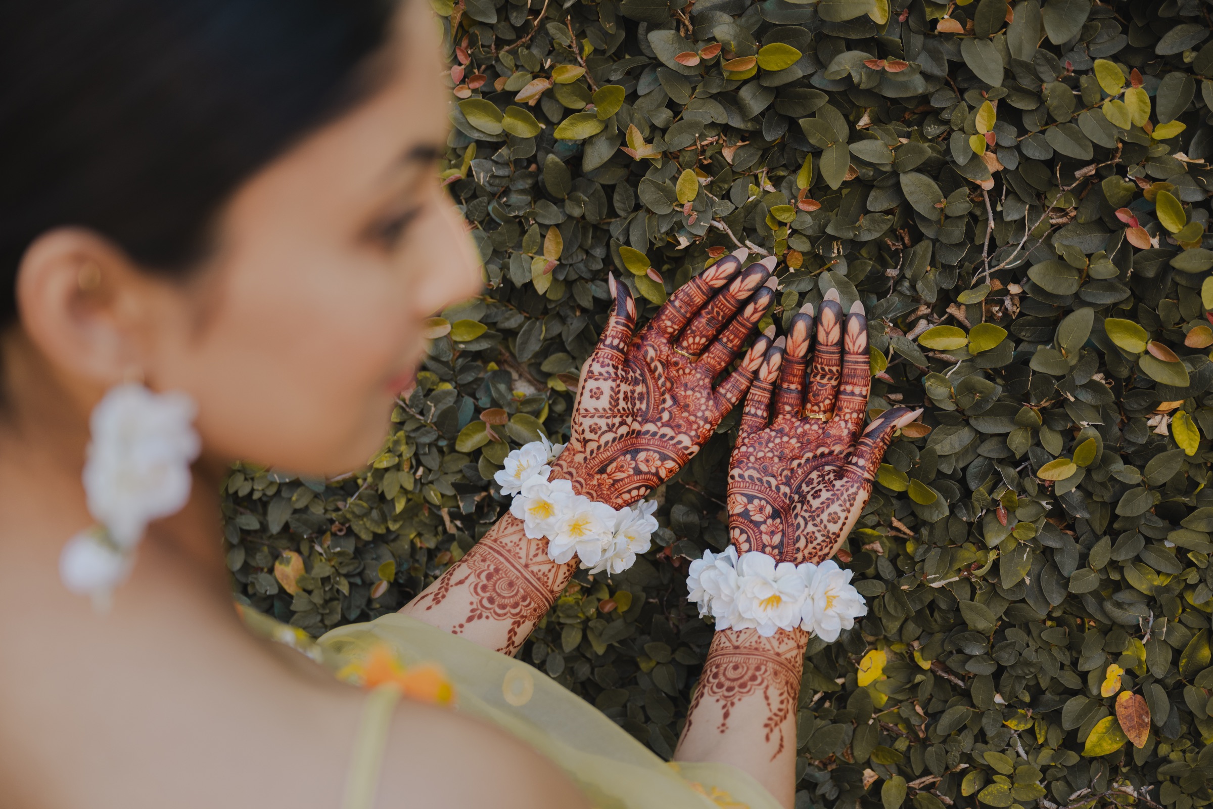 Intricate mehndi and floral jewelry photographed in natural light